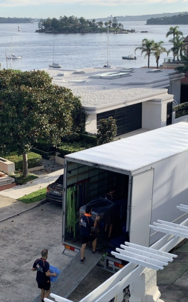 Professional movers carrying packed boxes into a moving truck