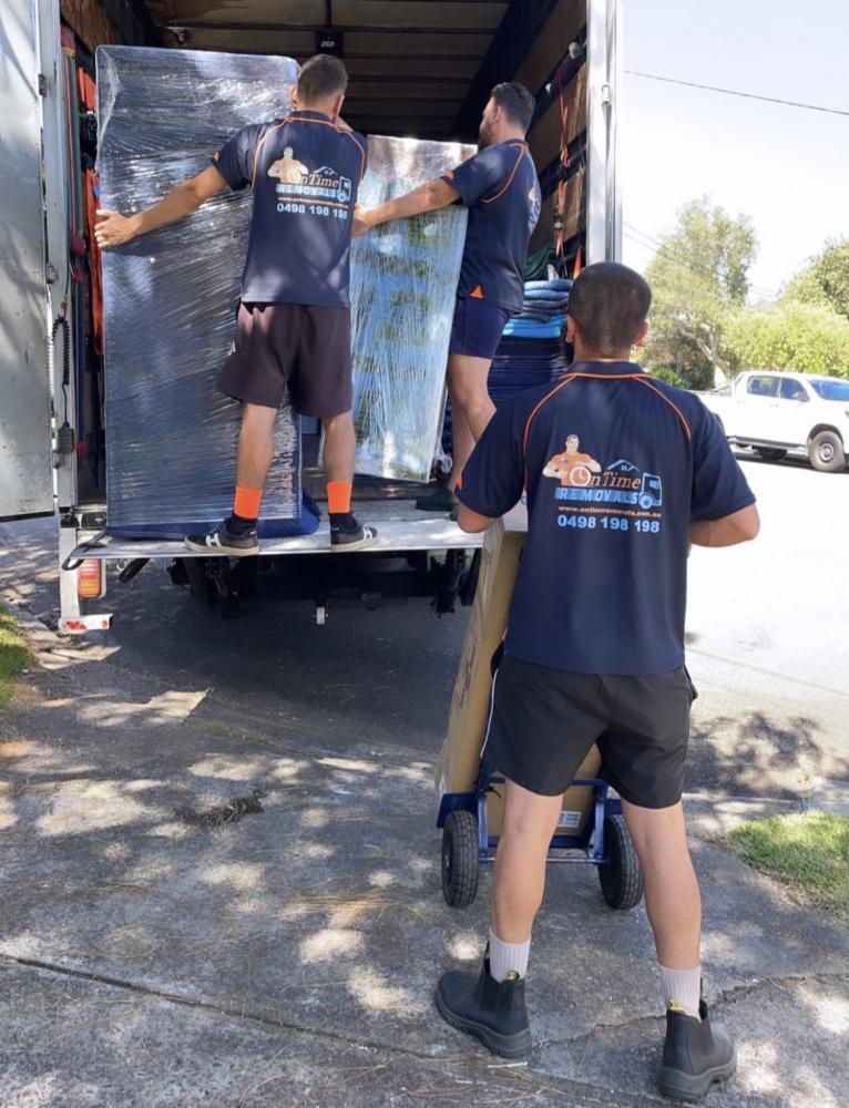 Experienced moving team loading furniture into a removalist truck