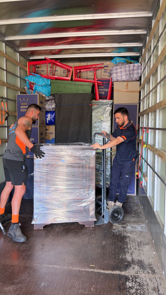 Removalist team organising packed cartons for efficient transportation