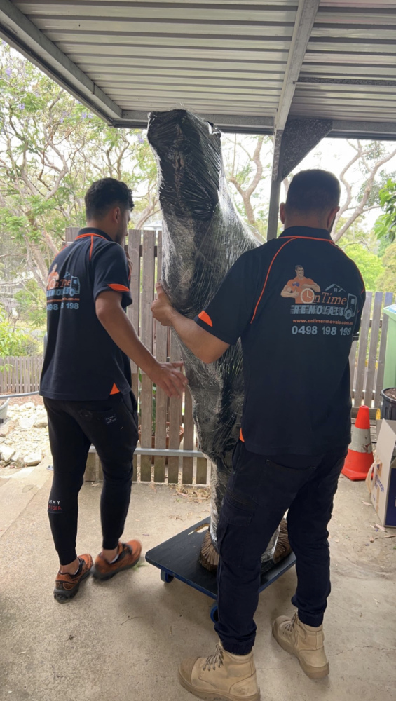 Removalists handling fragile household belongings during a move