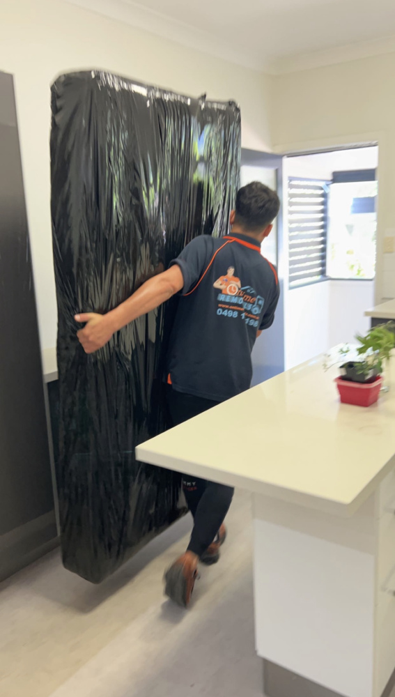 Removalist team carefully moving large appliances between homes