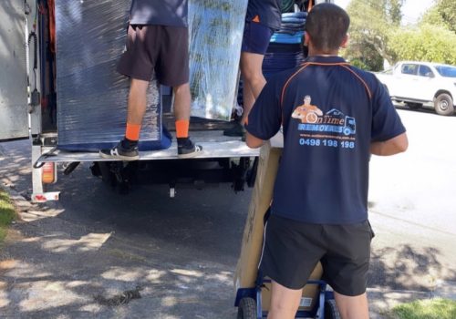 Experienced moving team loading furniture into a removalist truck