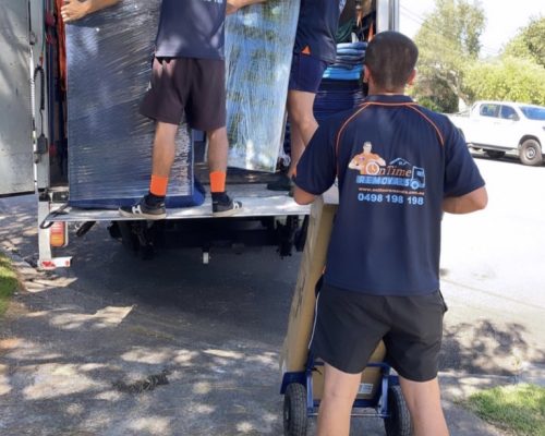 Experienced moving team loading furniture into a removalist truck