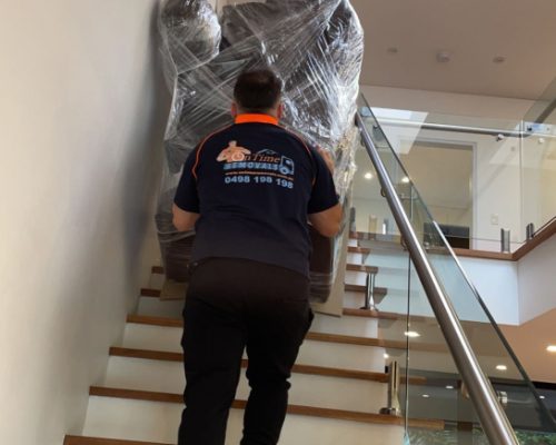 Removalist team carefully moving large appliances between homes