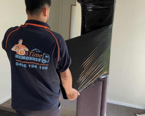 Professional furniture movers handling bulky household belongings