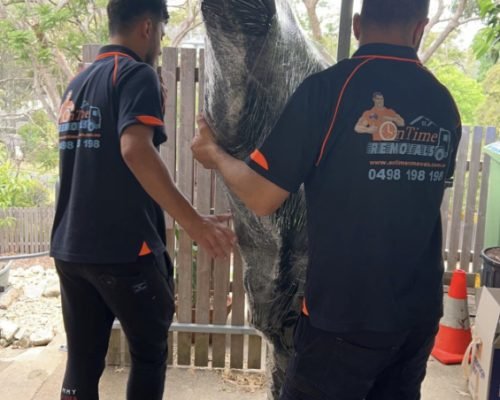 Removalists handling fragile household belongings during a move