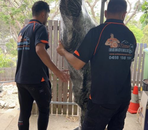 Removalists handling fragile household belongings during a move