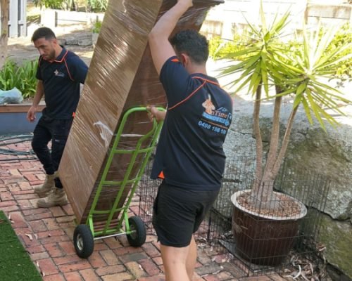 Reliable movers unloading household furniture at a new property