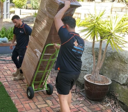 Reliable movers unloading household furniture at a new property