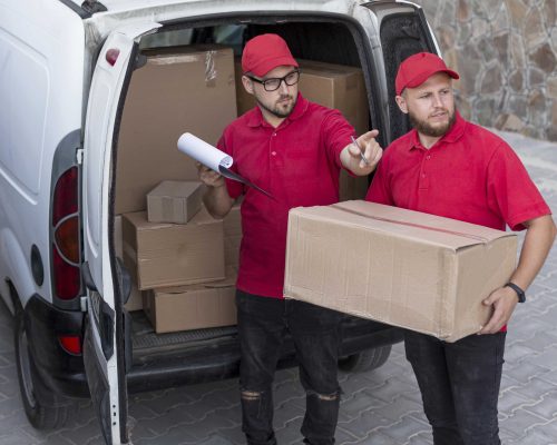 Reliable home movers carrying packed boxes into a new property